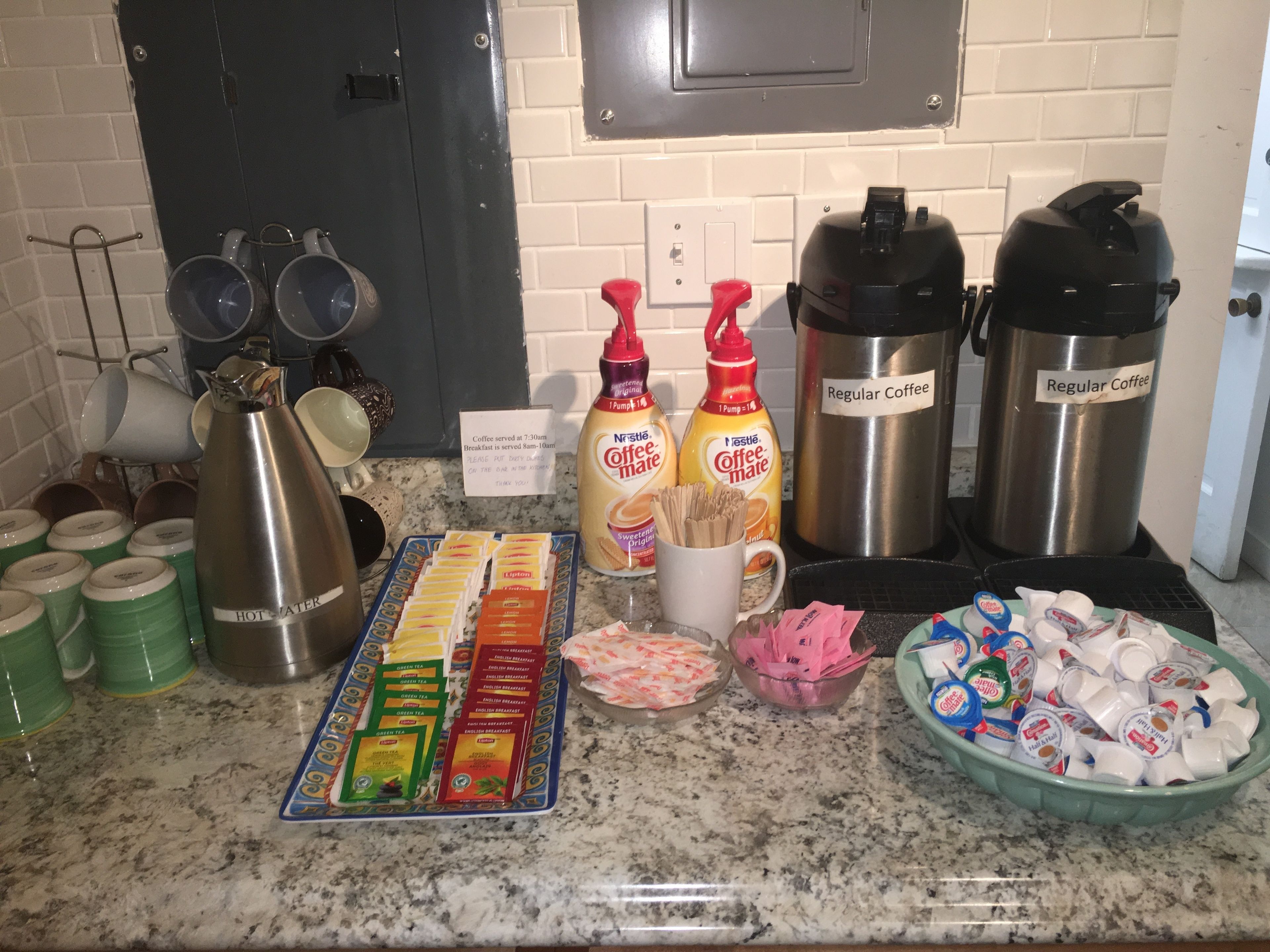 Una mesa de desayuno tipo buffet con diversas opciones de comida y bebidas.