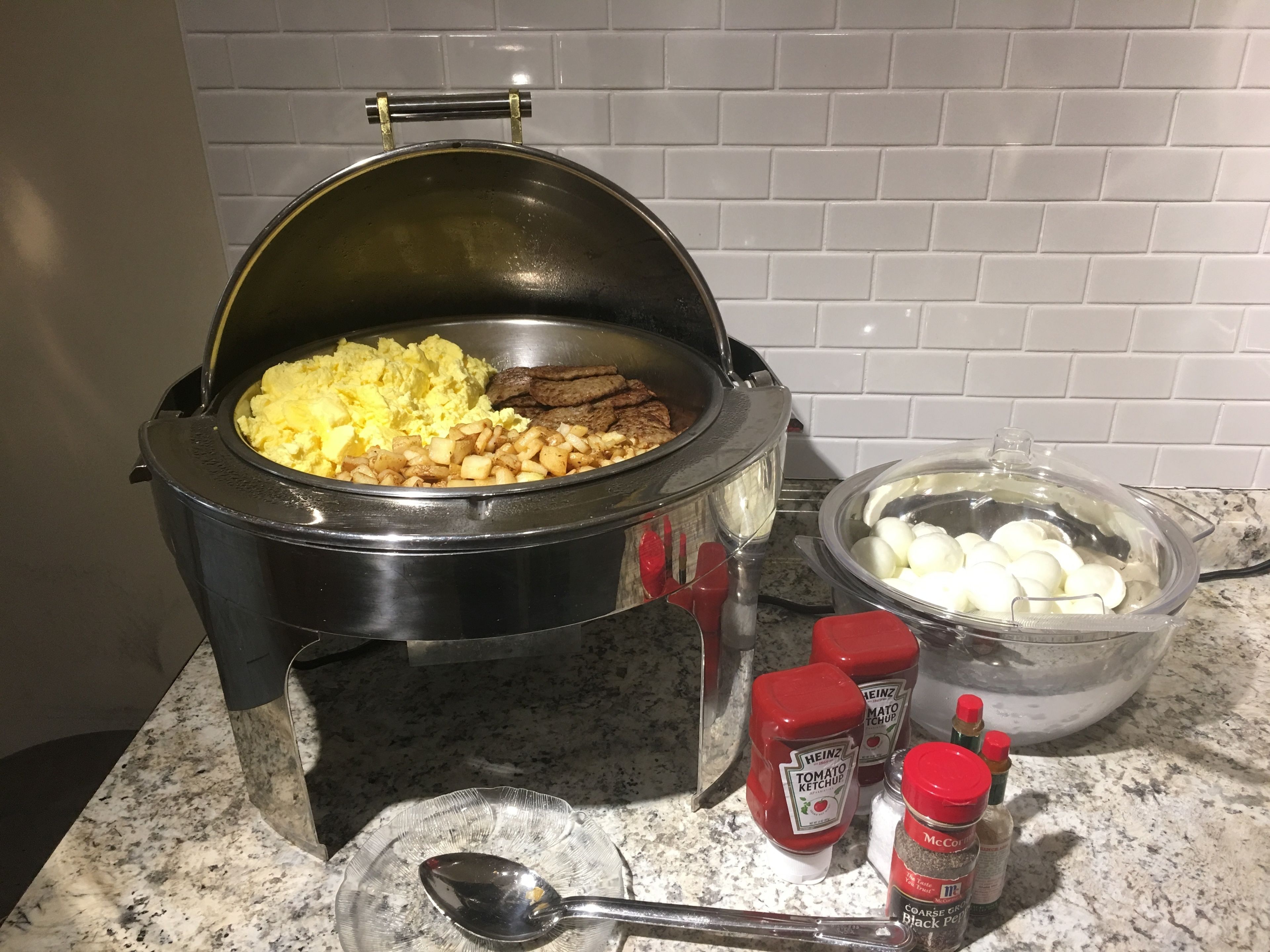 Ein Slow Cooker mit Rührei, Kartoffeln und Steak auf einer Granitarbeitsplatte.