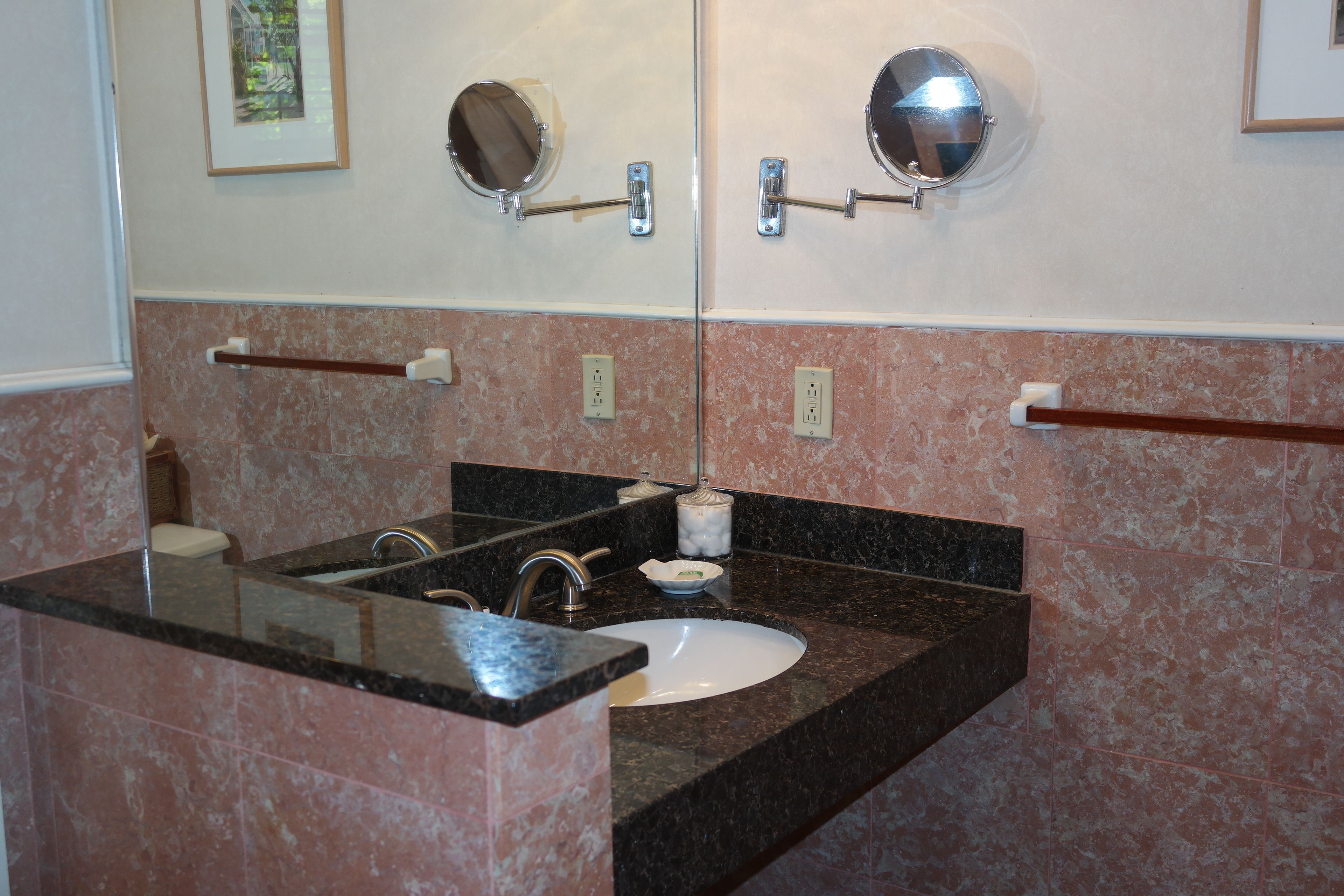 A bathroom with a sink, mirror, towel rack, and toilet.