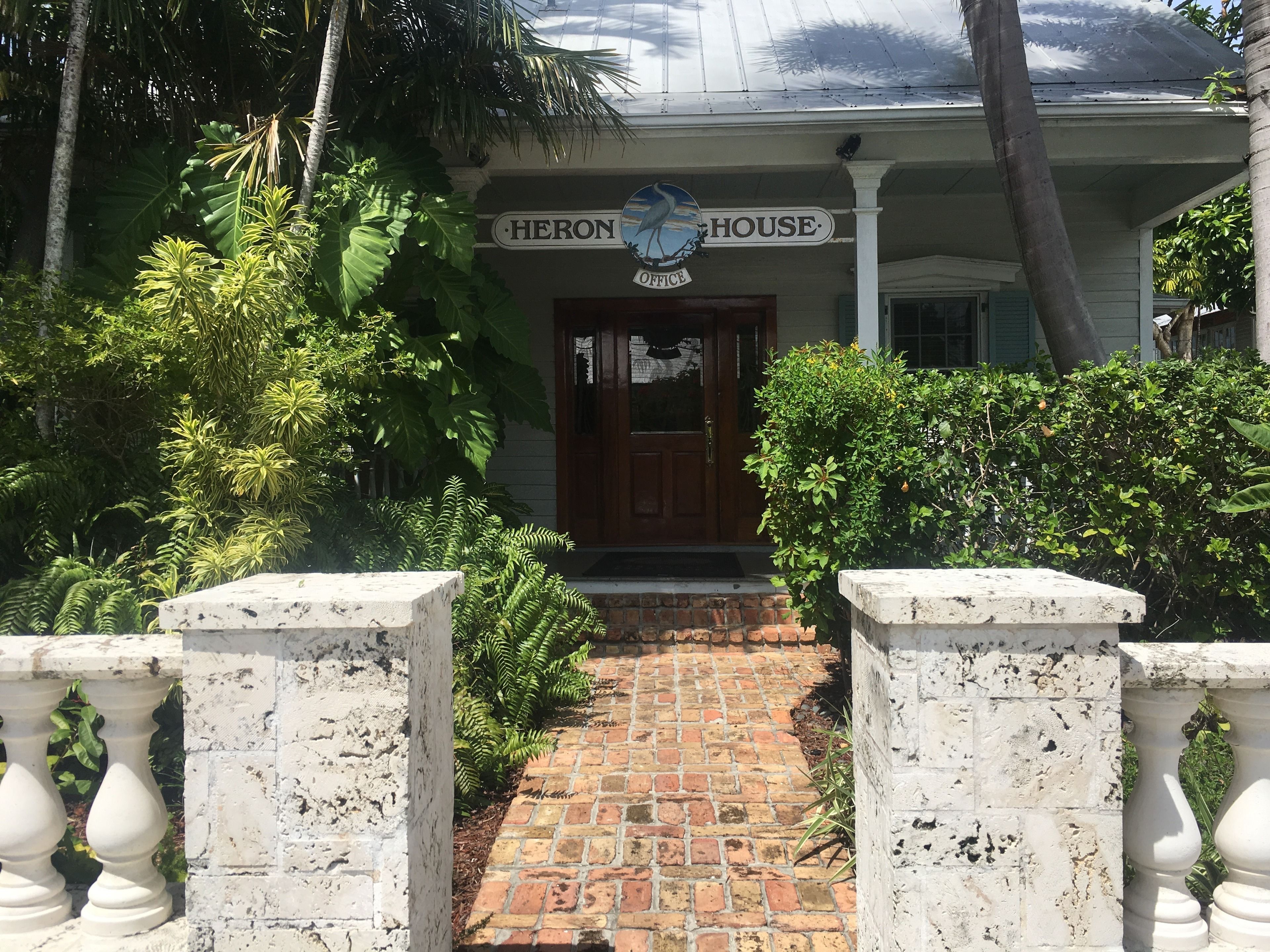 A house with a sign reading "HERON HOUSE OFFICE".