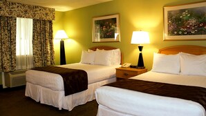 A hotel room with two beds, floral curtains, a painting, and two bedside lamps. - The University Inn at Emory (Atlanta)