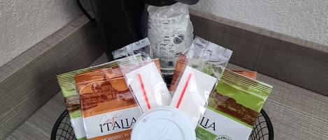 A coffee maker, a water dispenser, and a basket with coffee pods and a lid.