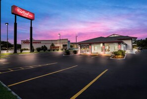 A Red Roof Inn with a parking lot and an Office Depot store in the background. - Red Roof Inn & Suites Thomasville (Thomasville)