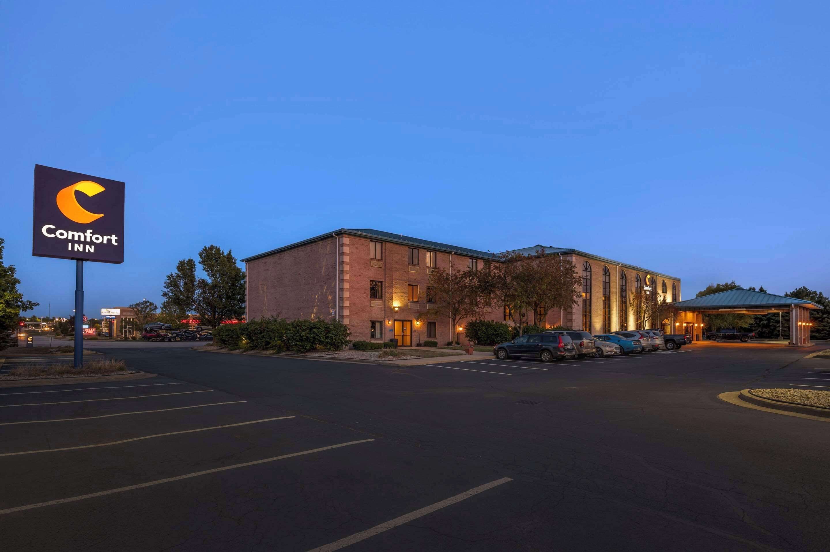 A Comfort Inn hotel with a brick facade, a parking lot, and a covered entrance.