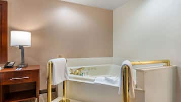 Un baño de hotel con una bañera, un tocador con una lámpara y un teléfono.