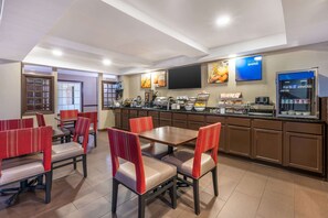 A restaurant with booths and tables, a buffet counter, and a television screen. - Comfort Inn Lafayette I-65 (Lafayette)