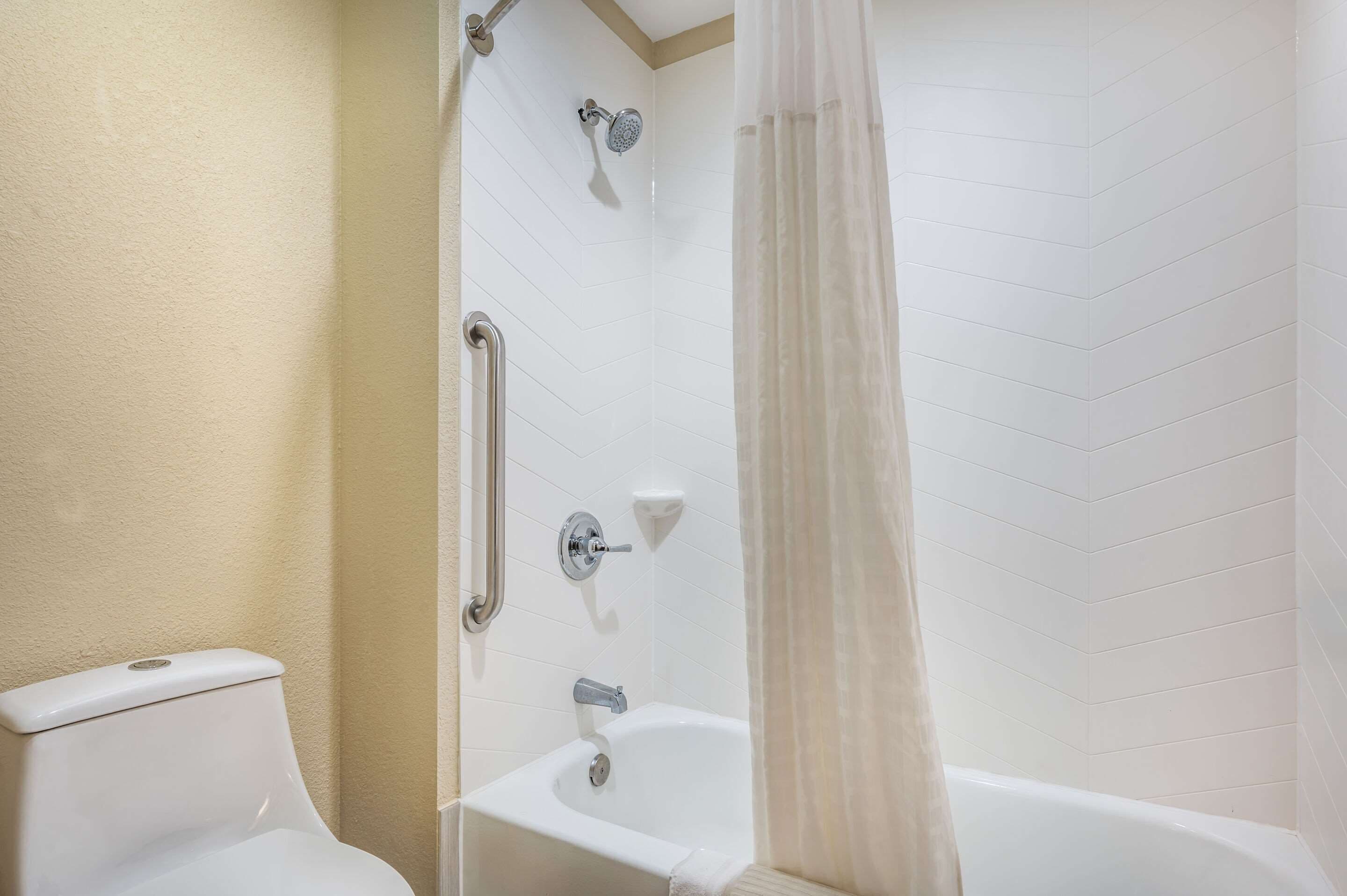 A bathroom with a toilet, a shower with a glass door, and a bathtub.