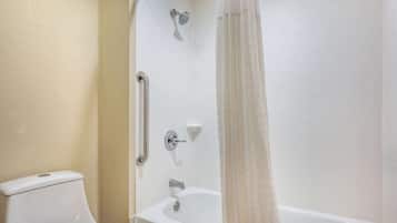 Ein Badezimmer mit Toilette, einer Duschkabine mit Glastür und einer Badewanne.