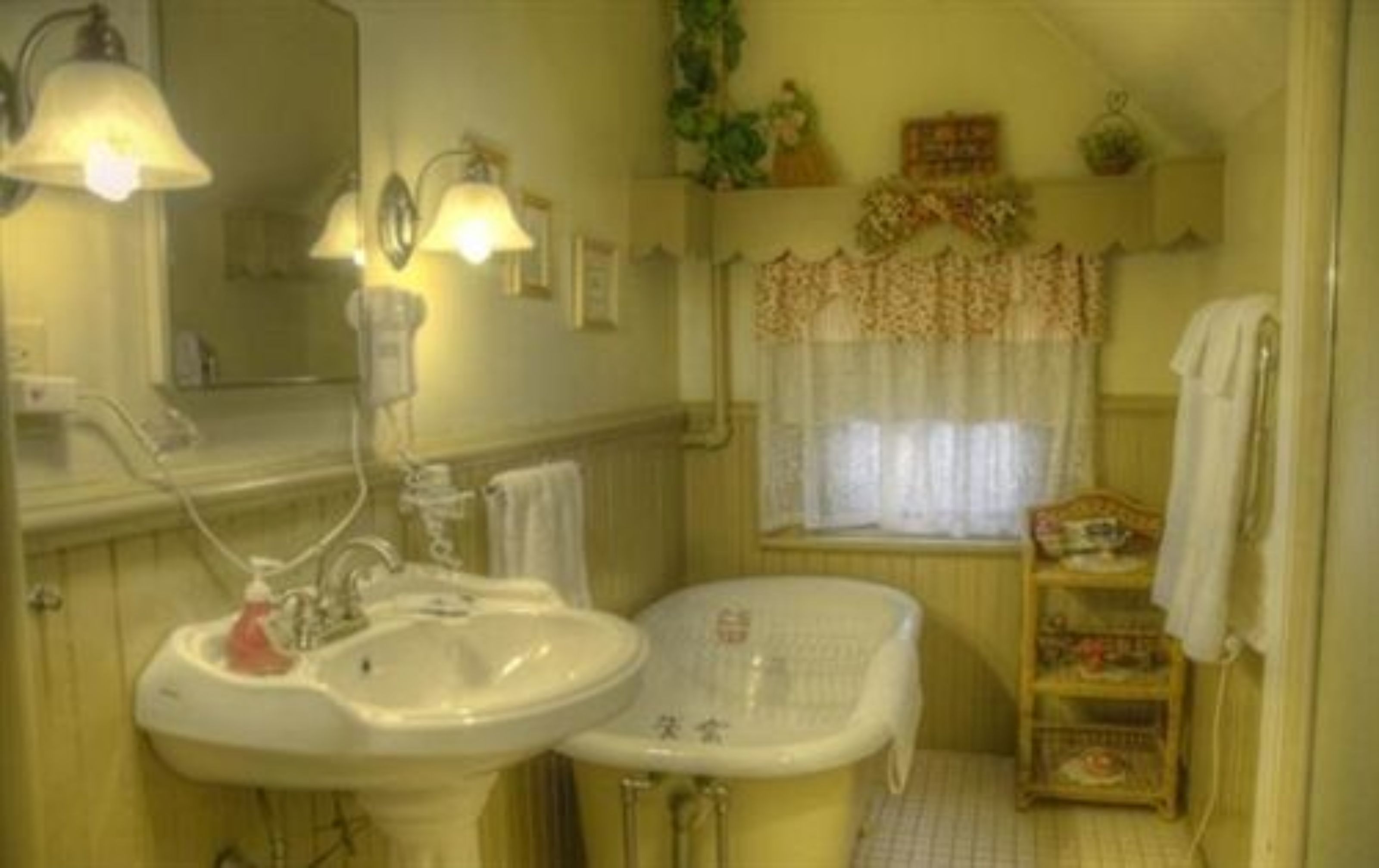 Une salle de bain avec un lavabo, un miroir et une fenêtre.