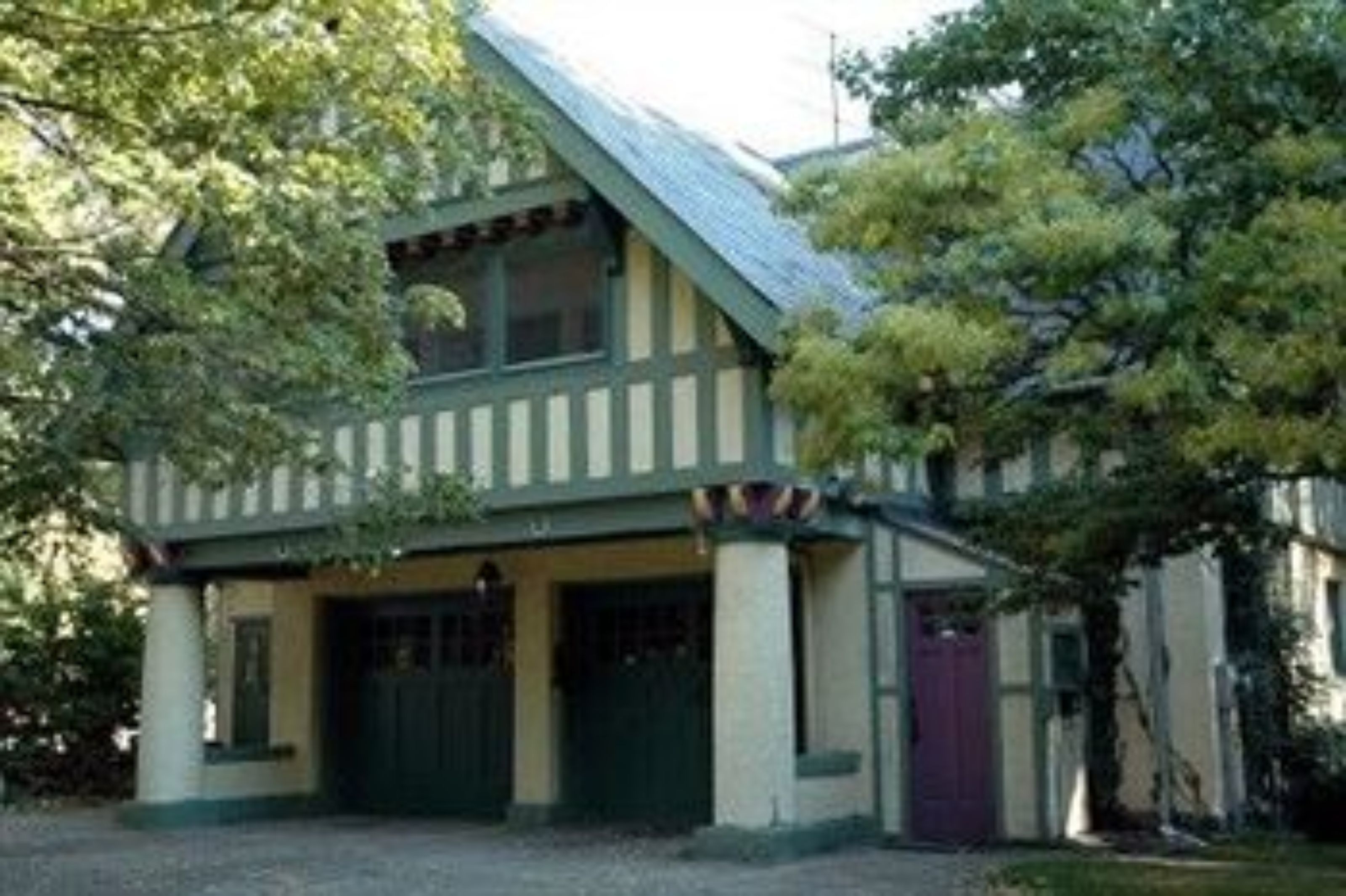 A two-story house with a gabled roof, a front porch, and a garage.