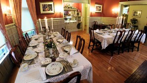 A dining room with a long table set for a meal, surrounded by chairs.