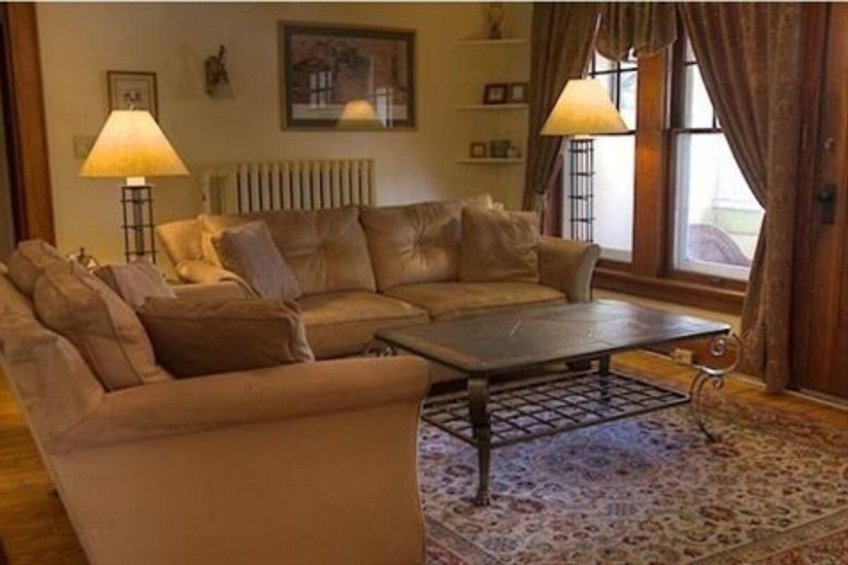 A living room with a brown leather sofa, a coffee table, and two floor lamps.