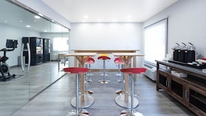 Une cuisine moderne dotée d’un îlot central, de tabourets de bar et d’un coin café.