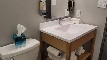 A modern bathroom with a toilet, sink, and mirror.