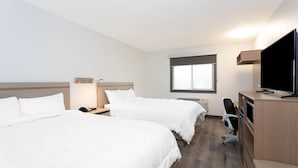Une chambre d’hôtel avec deux lits, un bureau, une chaise, une télévision et une fenêtre.