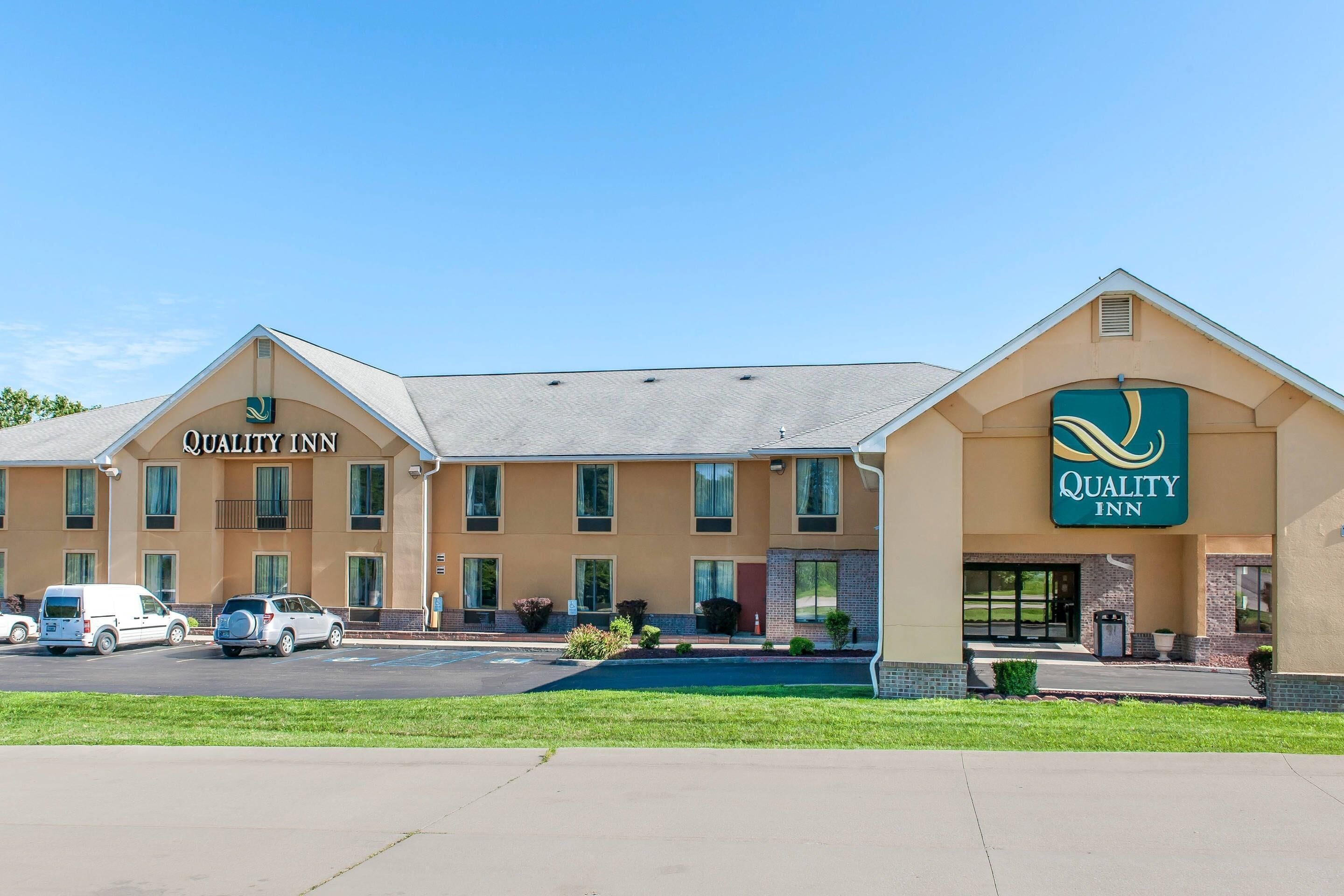 A Quality Inn hotel with a two-story structure, a parking lot, and a well-maintained lawn.