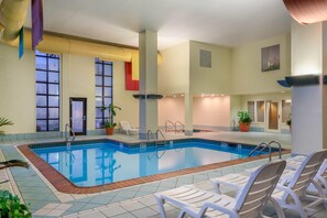 Una piscina techada, sillones reclinables de piscina