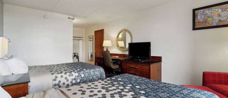 A hotel room with two beds, a desk with a TV, a chair, a mirror, and a map on the wall.
