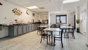 A spacious kitchen with a long counter, multiple chairs, and a dining table. - Econo Lodge Inn & Suites Waterloo Downtown (Waterloo)