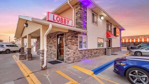 A building with a 'Lobby' sign, a stone facade, and a parking lot with cars. - Econo Lodge Hays I-70 (Hays)