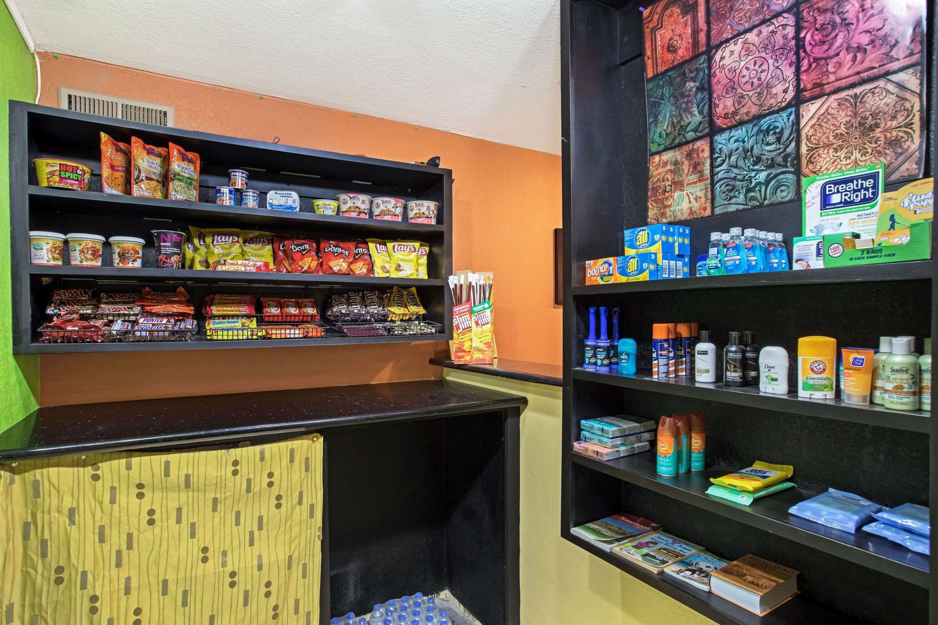 A store with shelves stocked with snacks, beverages, and toiletries.