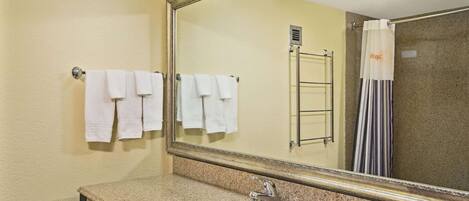 Une salle de bain équipée d’un lavabo, d’un miroir et d’un porte-serviettes.