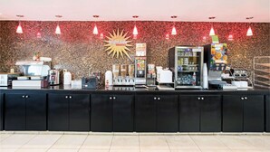 A counter with a coffee machine, a refrigerator, and a menu board.