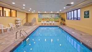 A swimming pool with a mural, chairs, and a 'No Diving' sign.