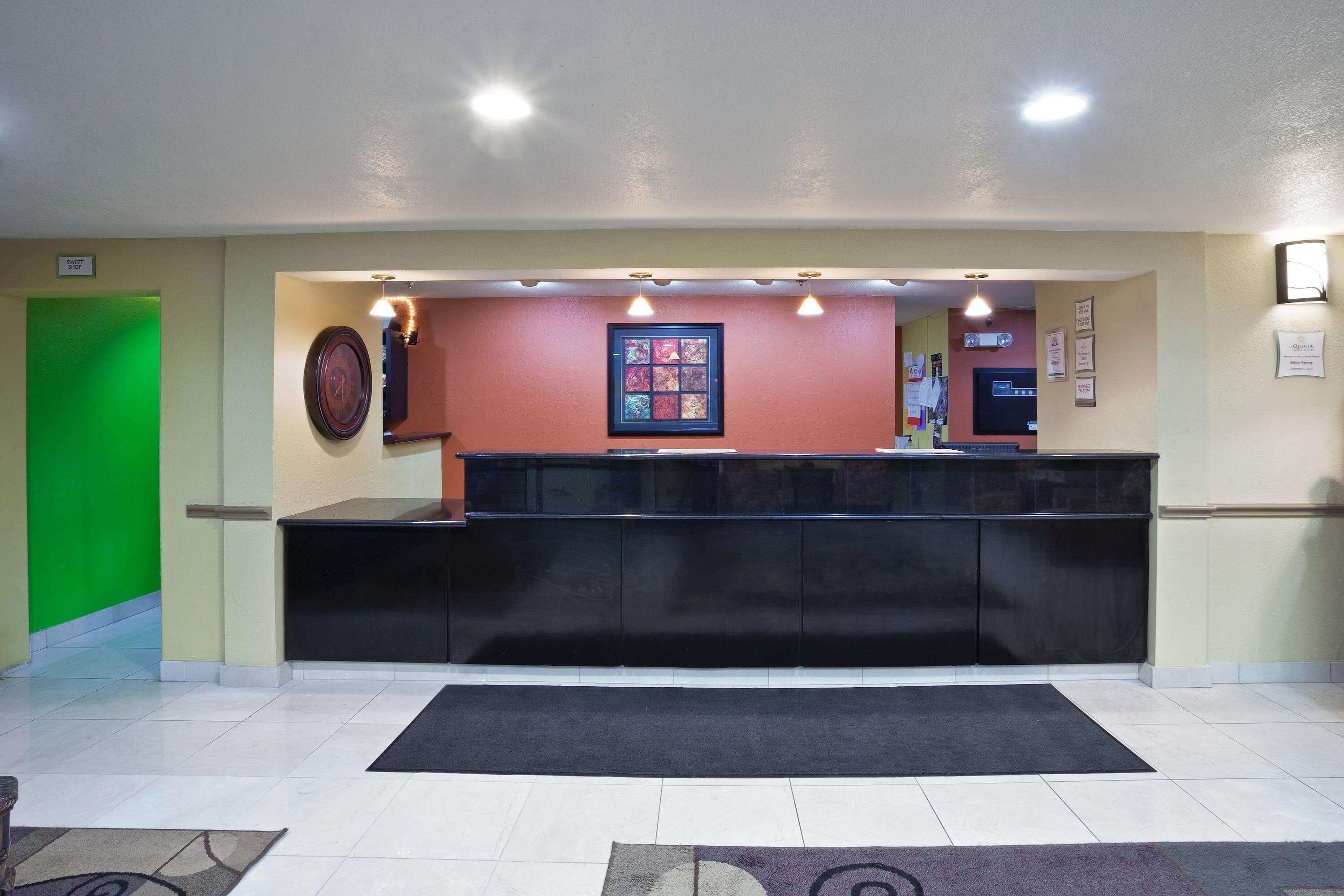 A reception area with a black counter, a green door, and a framed artwork on the wall.