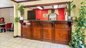 En receptionsdisk i træ, røde vægge og et skilt for Ecoma Lodge.