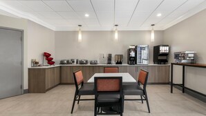 A modern kitchen with a central island, built-in appliances, and a seating area with chairs. - Best Western Eagles Inn (Morehead)