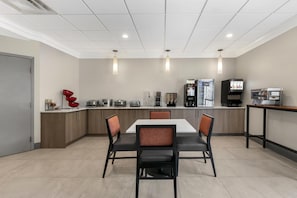Une cuisine moderne dotée d’un îlot central, d’appareils électroménagers intégrés et d’un coin repas avec des chaises.