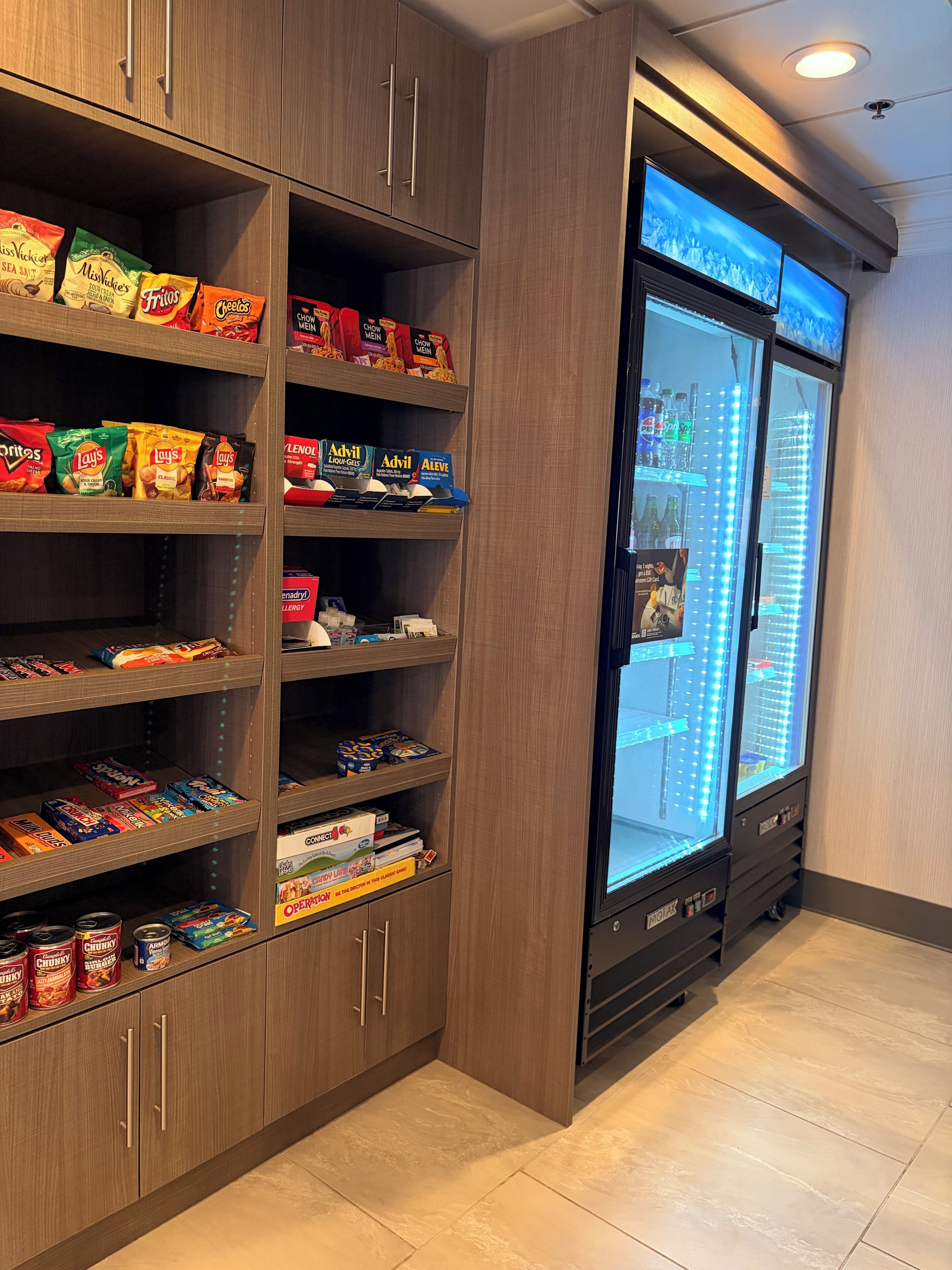 Un espace de vente proposant des collations et des boissons, avec un assortiment varié de produits et un présentoir réfrigéré.