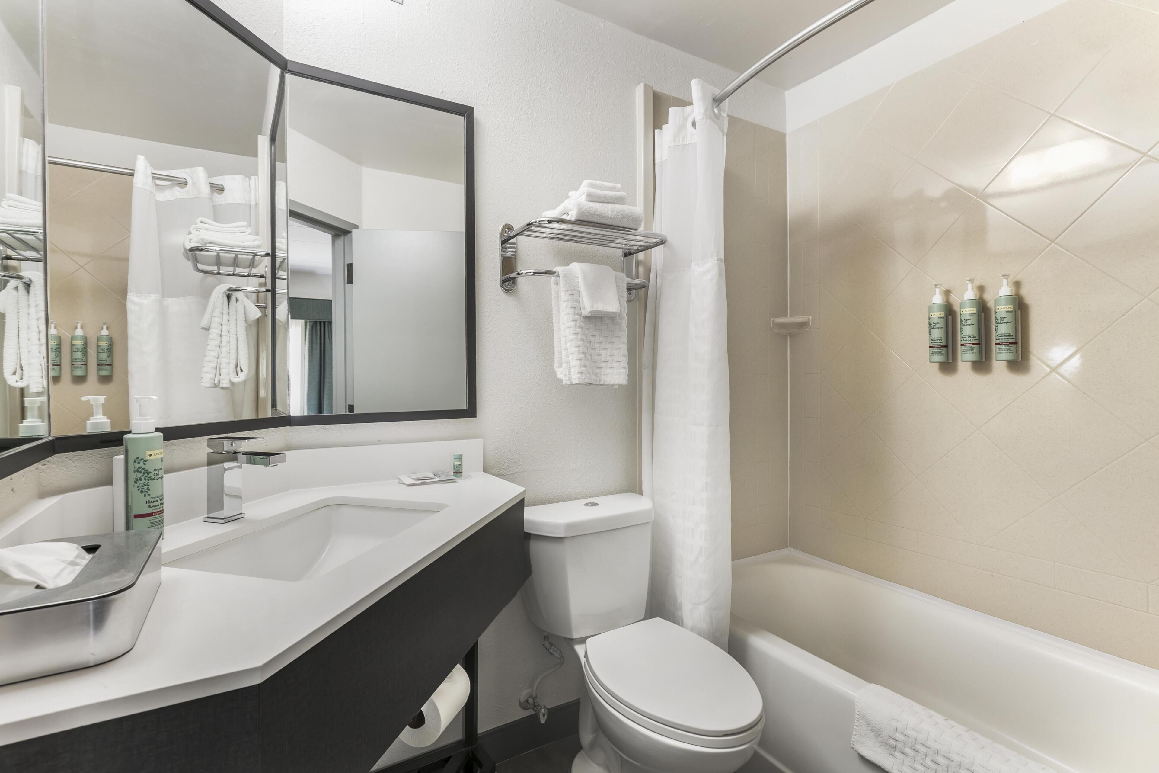 A modern bathroom with a sink, toilet, and shower.