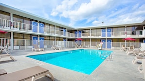 Et hotel med swimmingpool, flere balkoner og udendørs siddeområder.