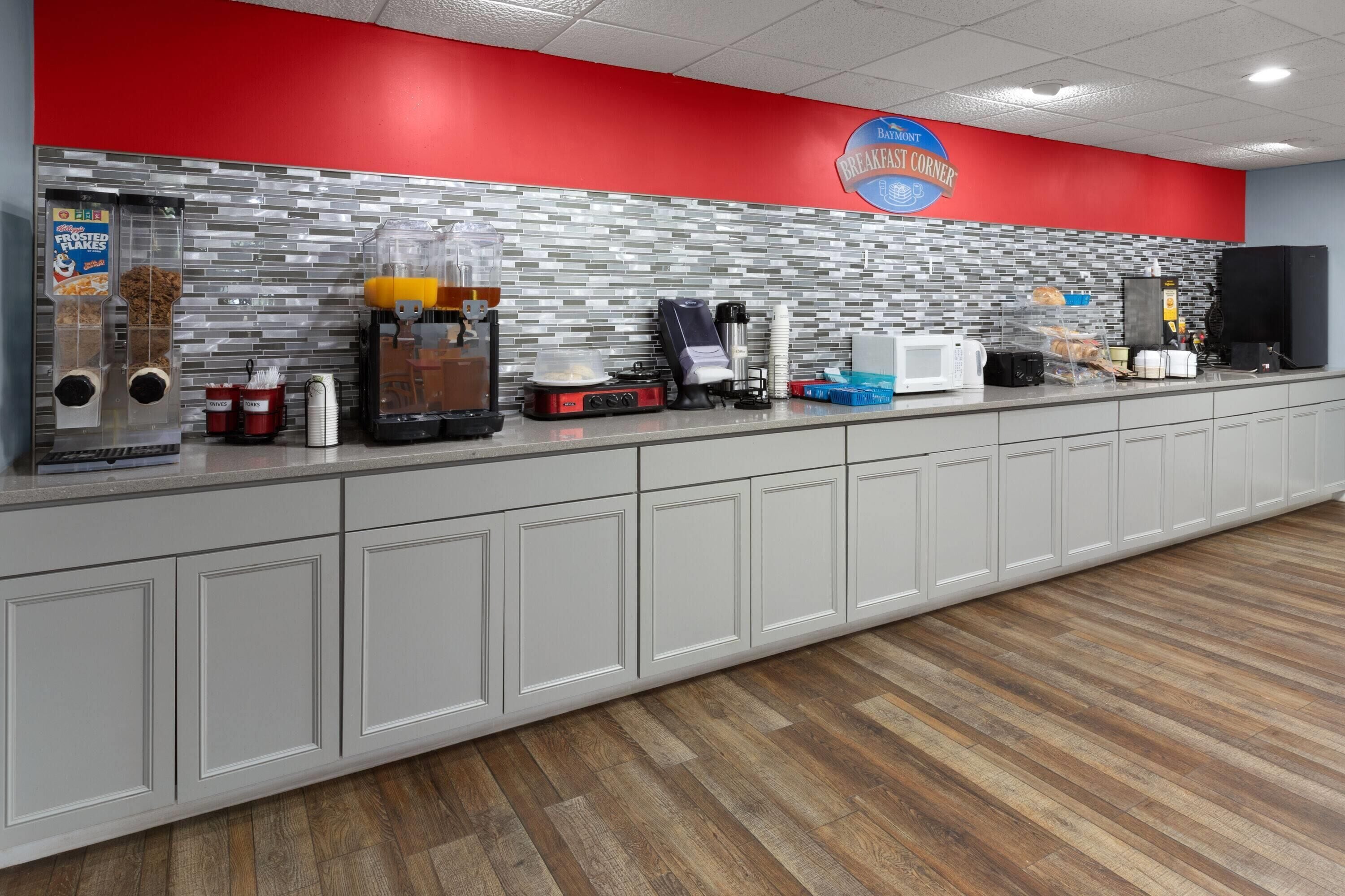 A breakfast counter with a red and white color scheme, a coffee machine, and various food items.