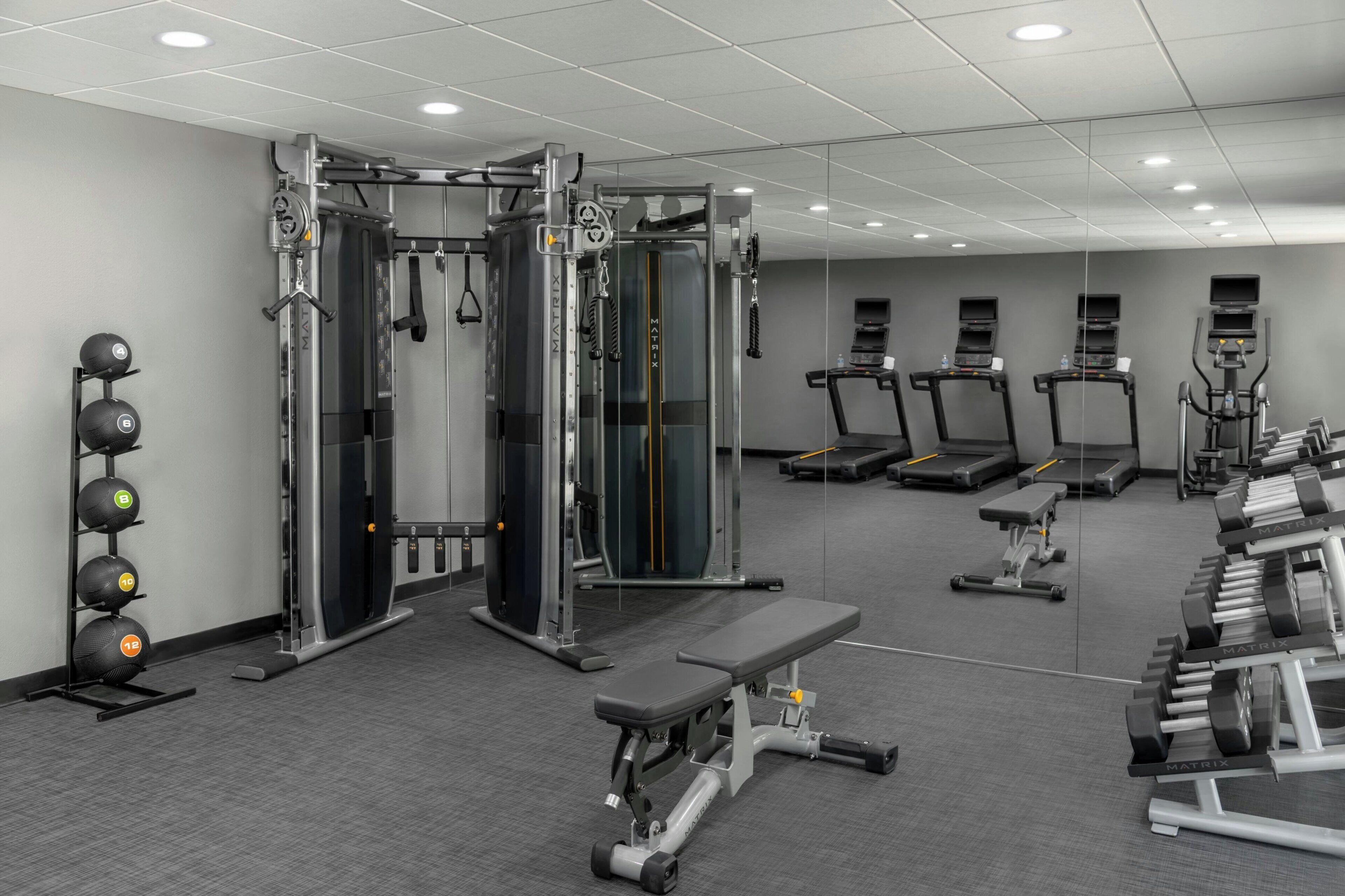 A gym with various exercise equipment, treadmills, and weight machines.