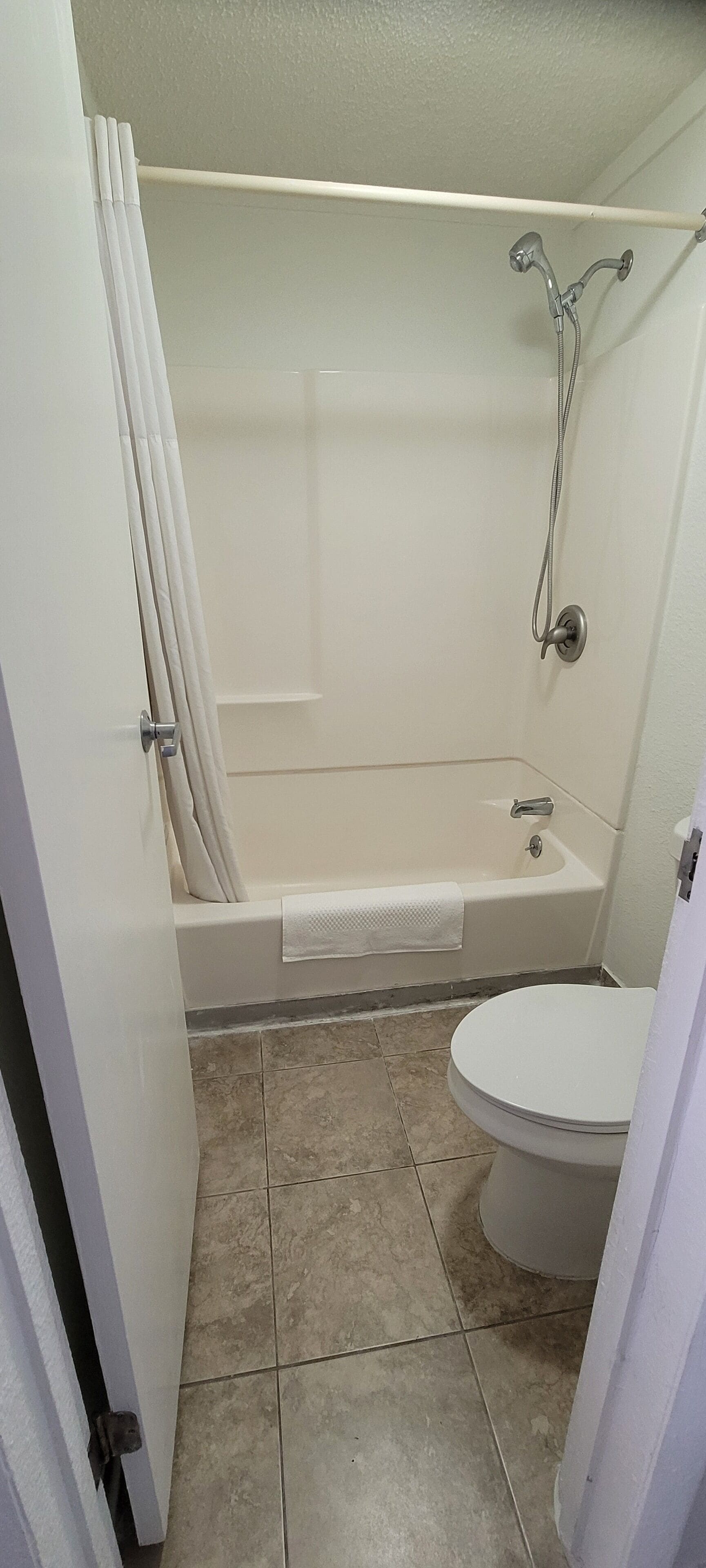 A bathroom with a bathtub, shower, and toilet.