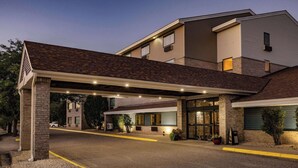 Un hôtel doté d’une entrée couverte, d’une façade en briques et d’un parking.