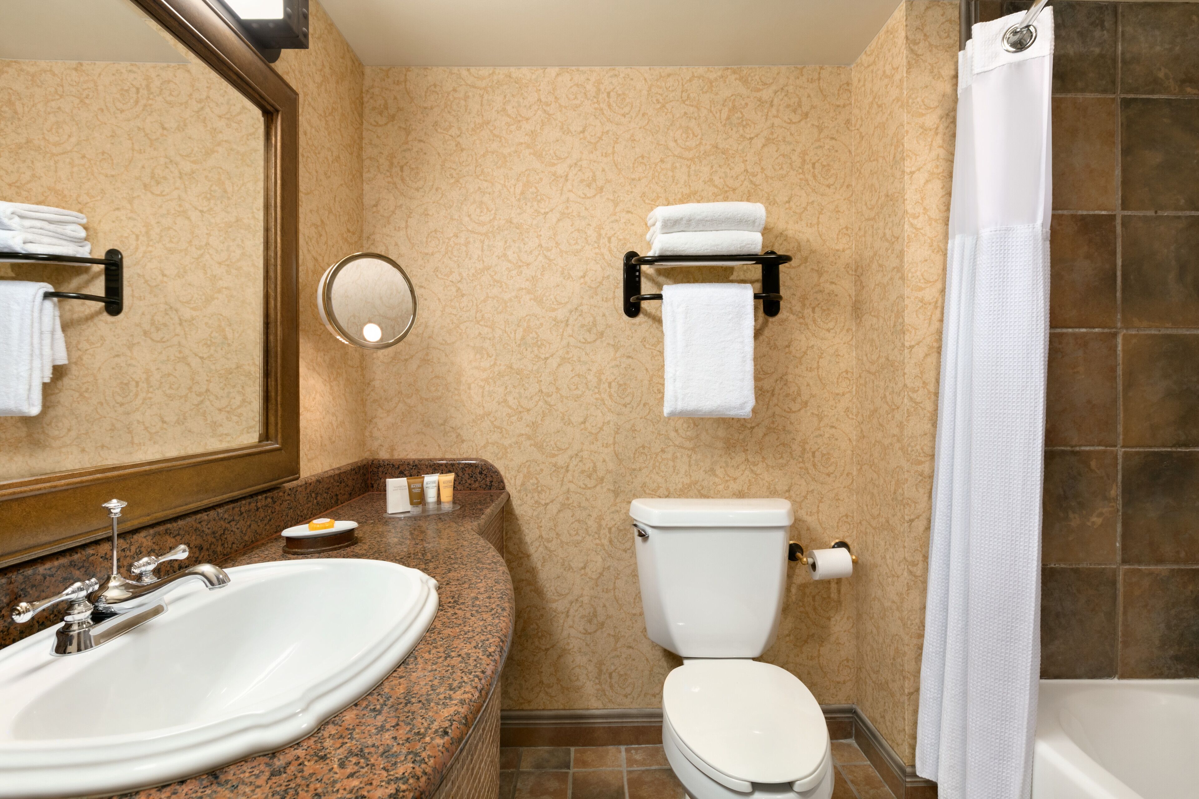 A bathroom with a sink, toilet, and shower.