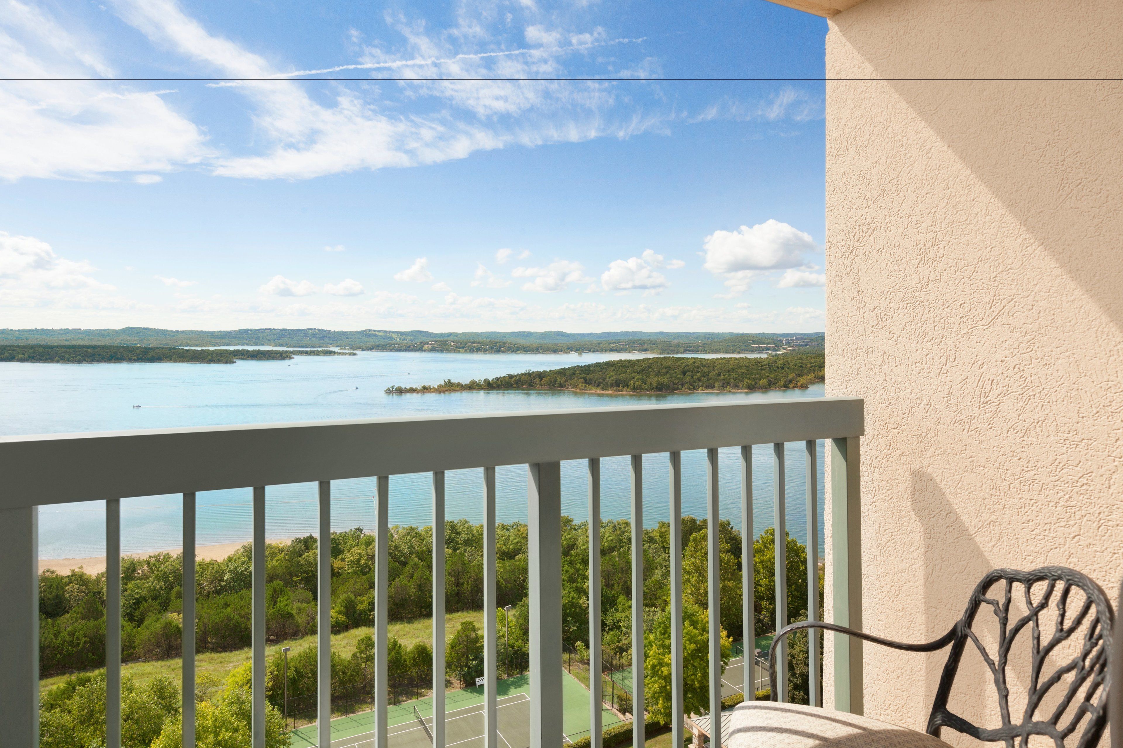A balcony with a view of a lake and distant land.
