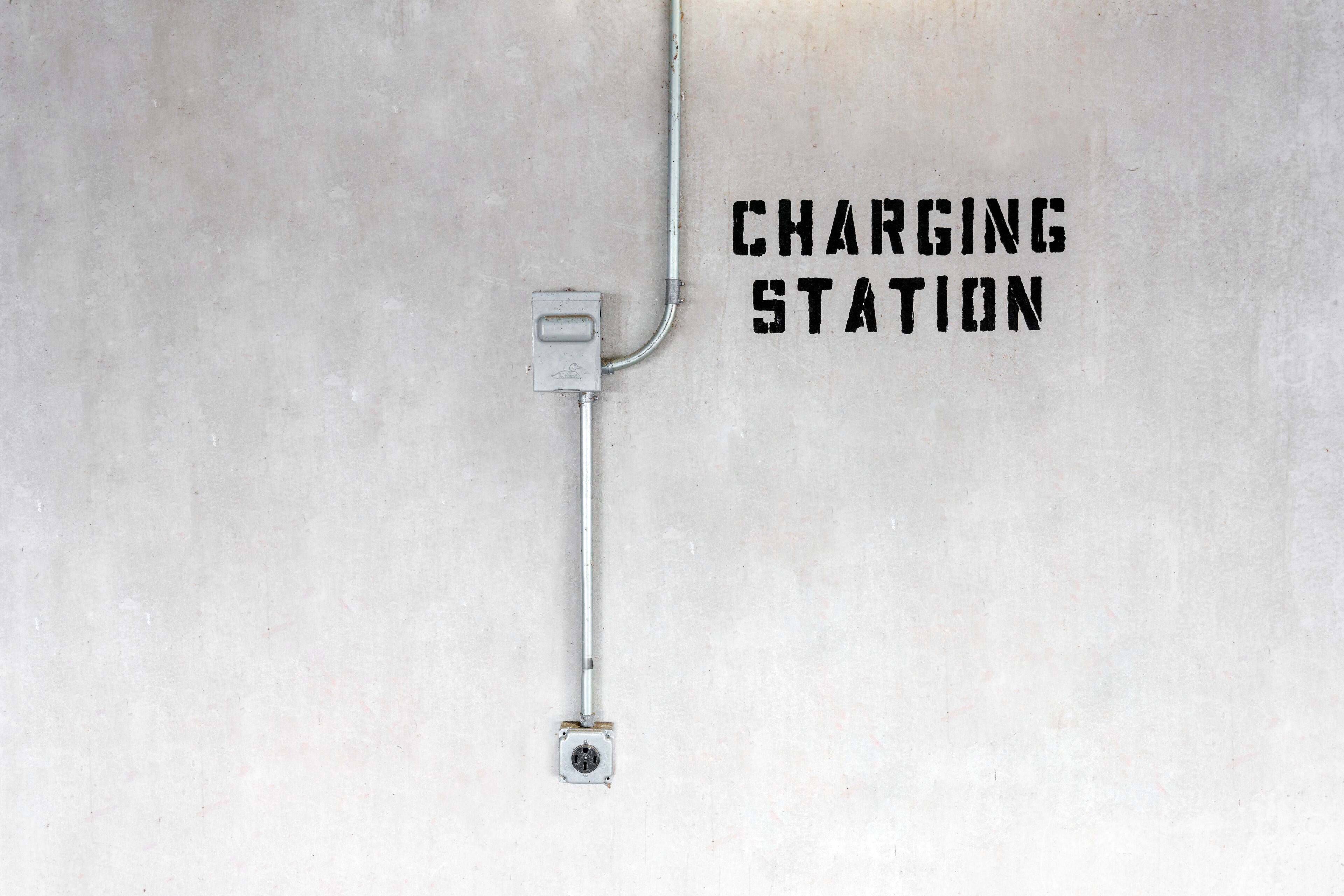 Une borne de recharge fixée à un mur en béton.