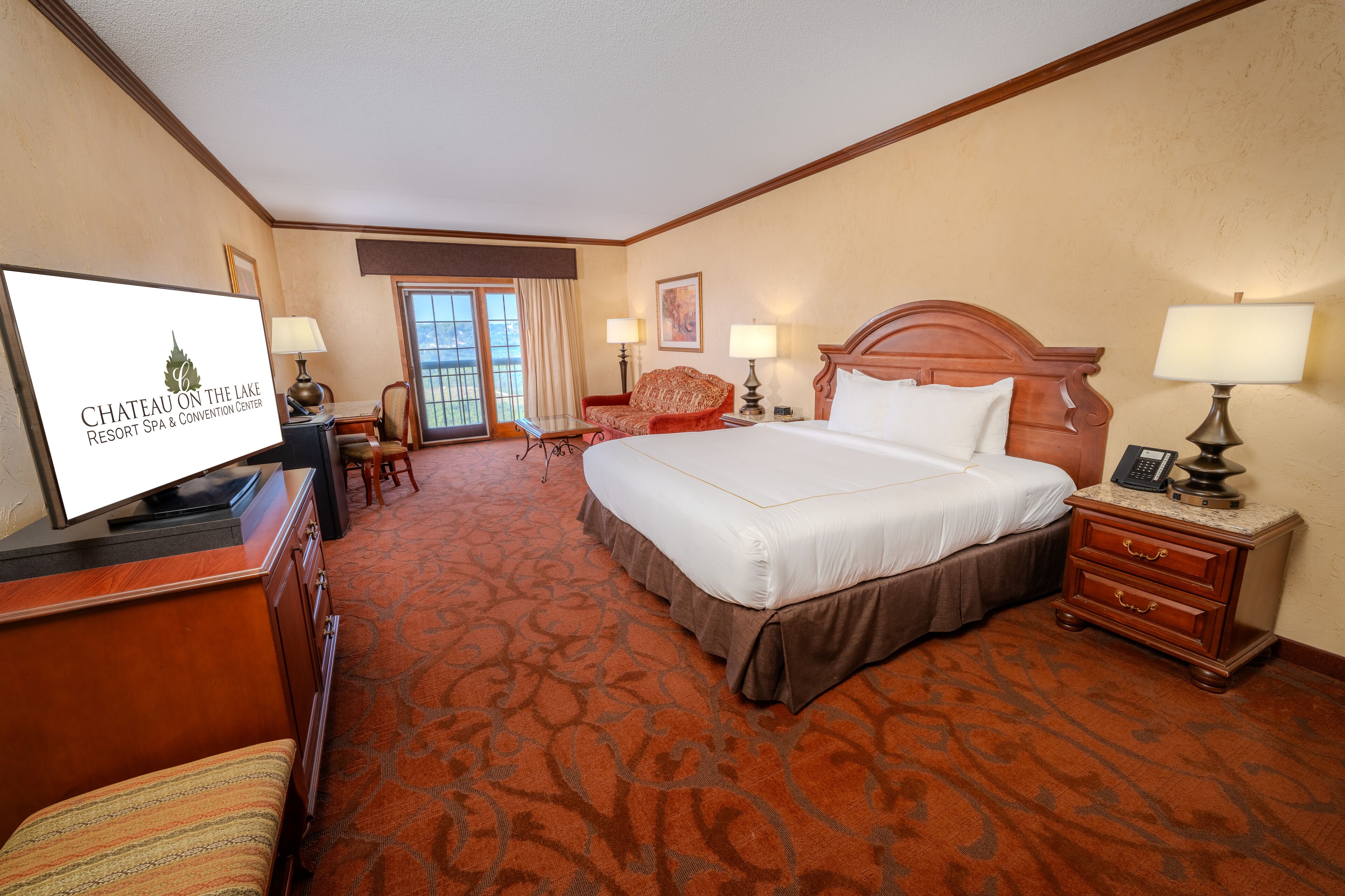 Une chambre d’hôtel avec un grand lit, un bureau, une chaise, une télévision et une vue sur l’extérieur.