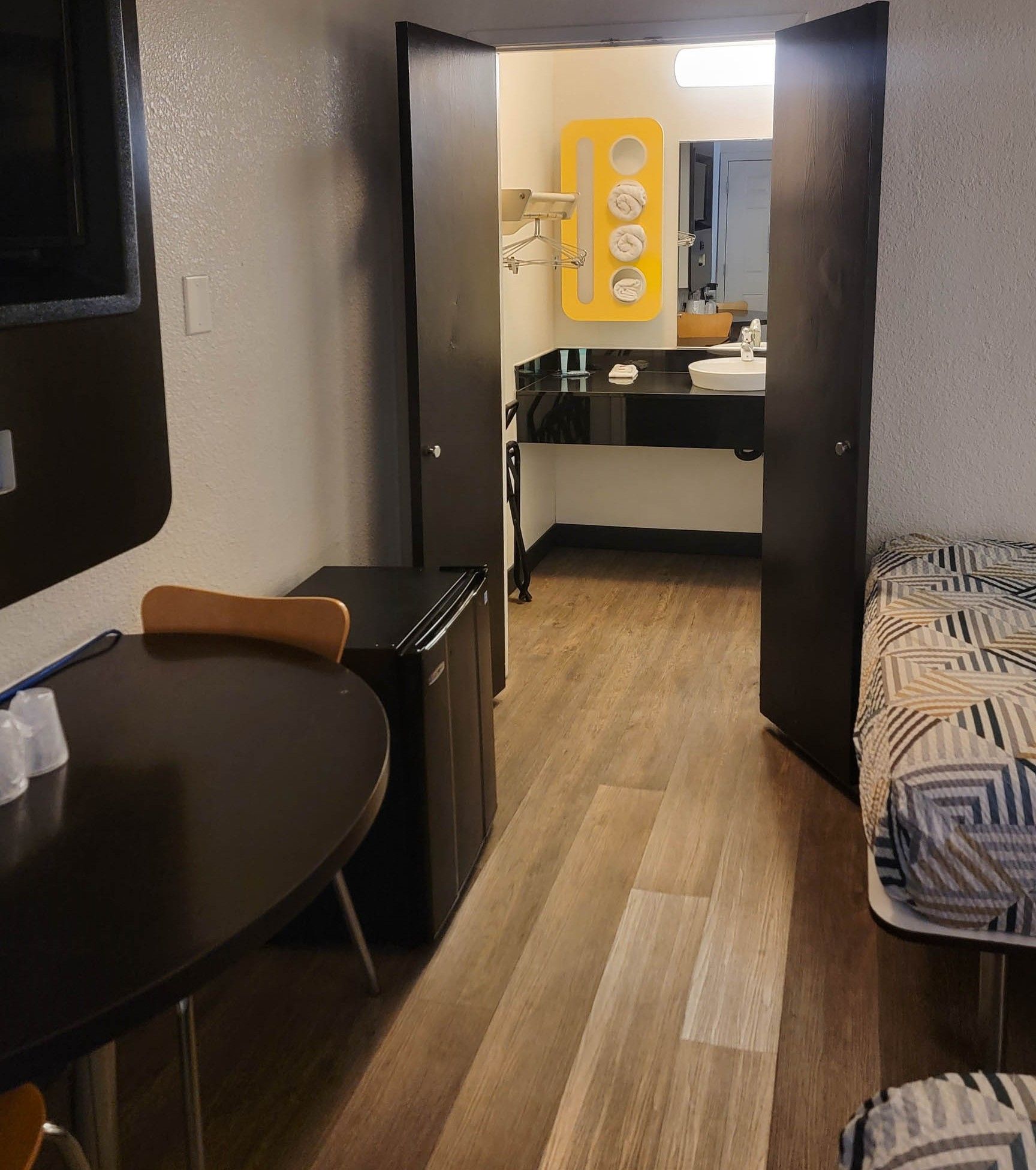 Quarto de hotel compacto com cozinha compacta, espaço para refeições e uma cama.