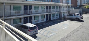 A multi-story motel with individual rooms numbered 407 to 405, a parking area, and a white pickup truck parked in the lot. - Studio 6 Suites Las Vegas, NV – Tropicana (Las Vegas)