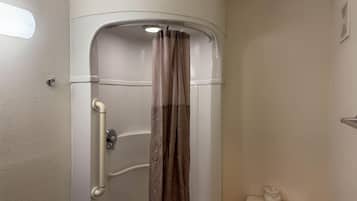 A bathroom with a shower enclosure, a toilet, and a towel rack.