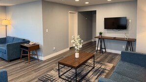 A modern living room with a sofa, coffee table, and TV. - Studio 6 Suites Las Vegas, NV – Tropicana (Las Vegas)