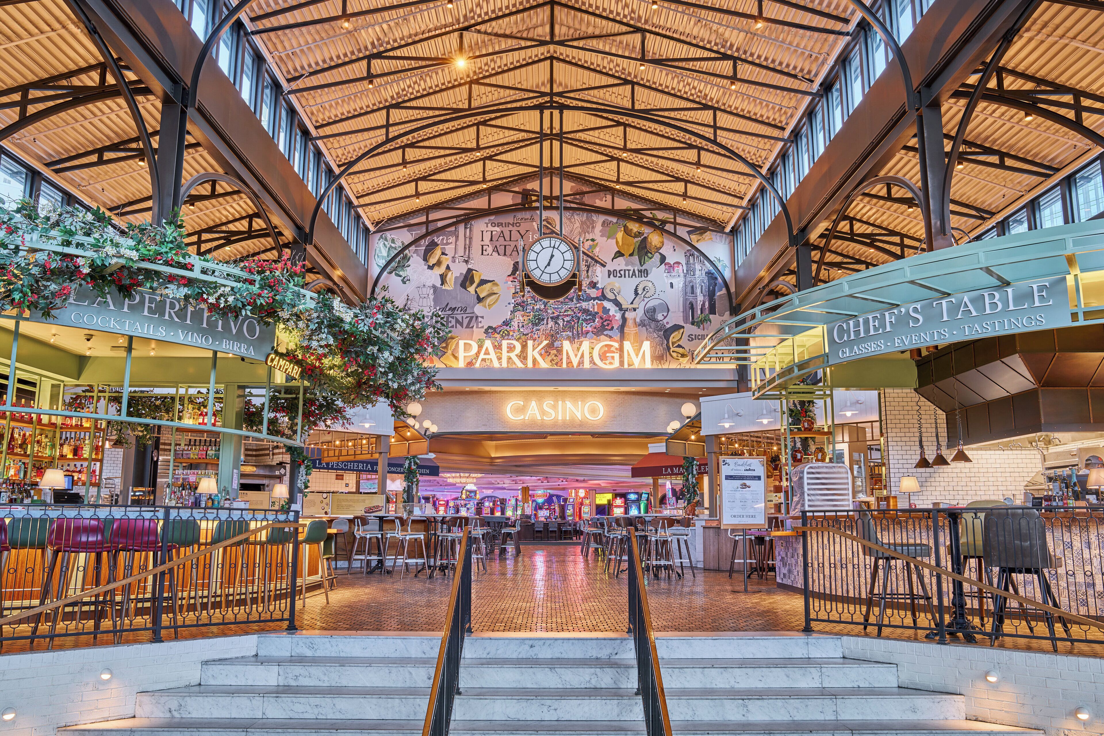 A spacious indoor area with a high ceiling, featuring a casino and a bar area with seating.