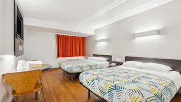 Una habitación de hotel con dos camas, un escritorio y una silla.