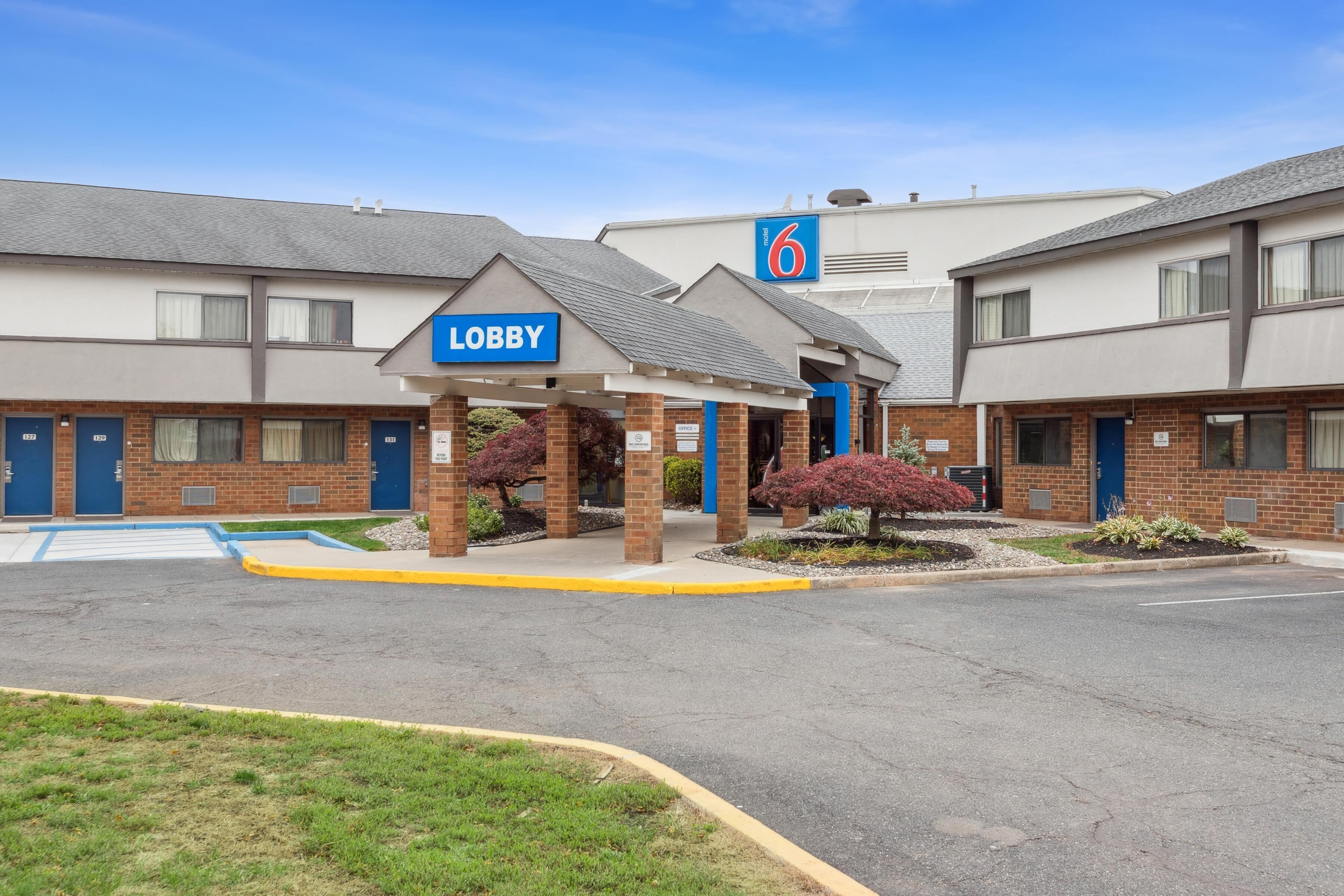 Un motel con un cartel que dice 'Lobby', un cartel con el número '6' y el número '6' en el edificio.